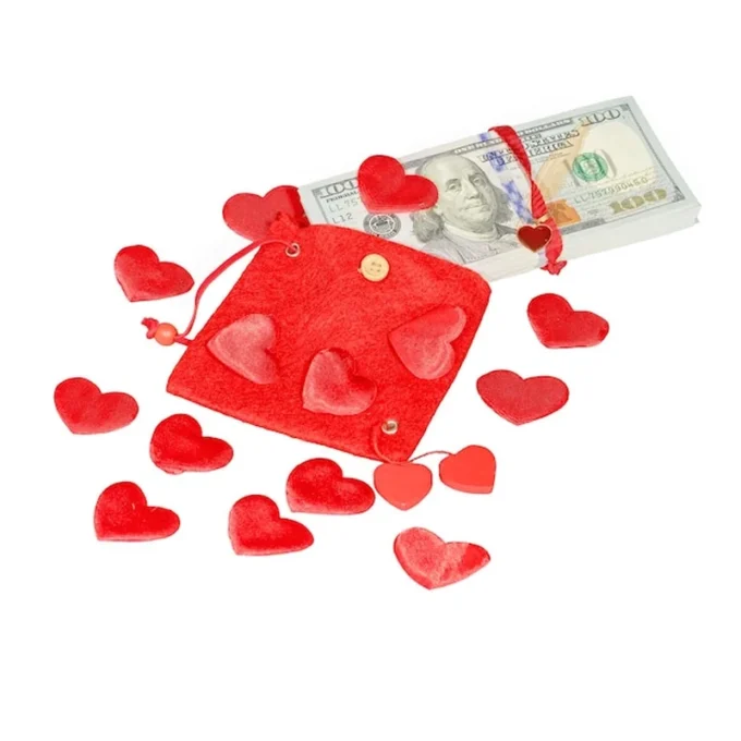 Pakiet dolarów w czerwonym woreczku z czerwonymi sercami na białym tle