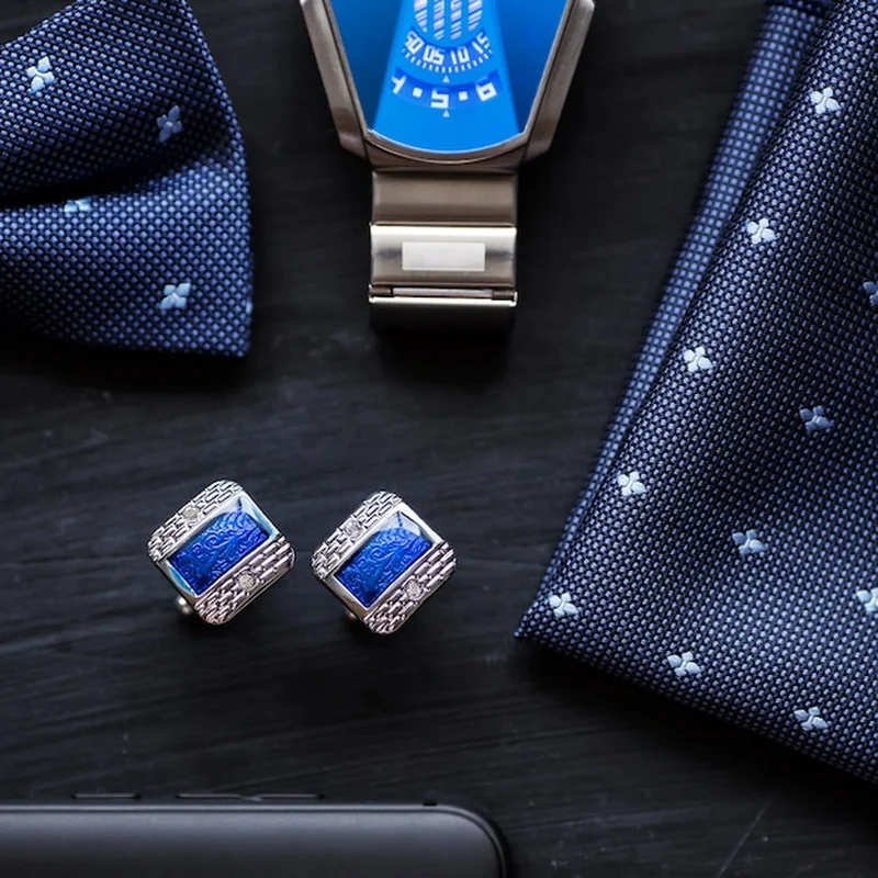 Męskie spinki do mankietów, zegarek w stylu motyla i smartfon z bliska