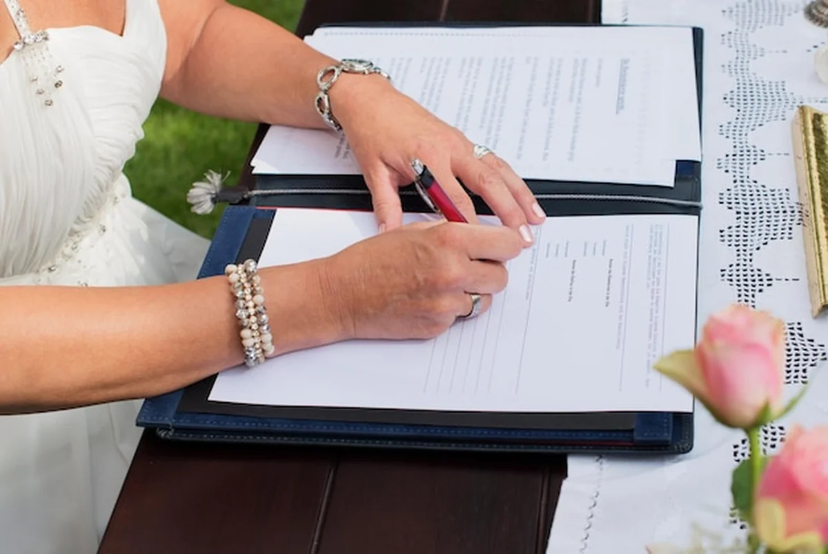 Panna młoda podpisuje umowę małżeńską po ceremonii ślubnej
