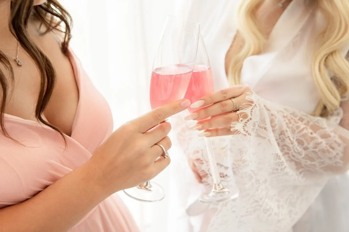 Panna młoda i druhna podczas ślubu, toast różowym szampanem